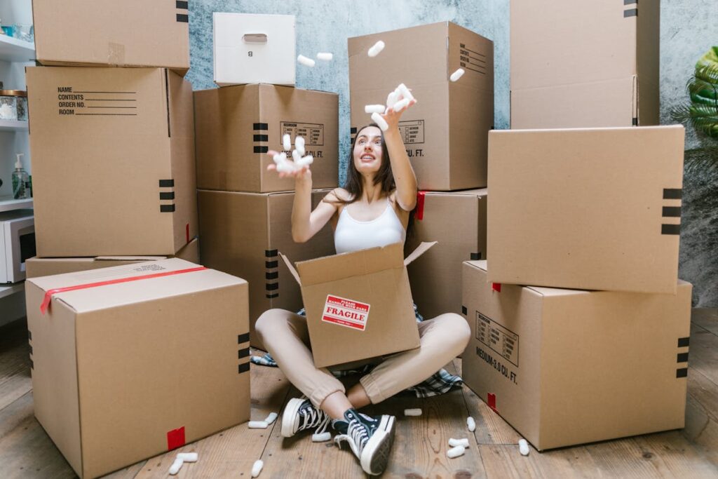 Woman sitting with packed boxes ready to move abroad after getting PR through immigration consultant